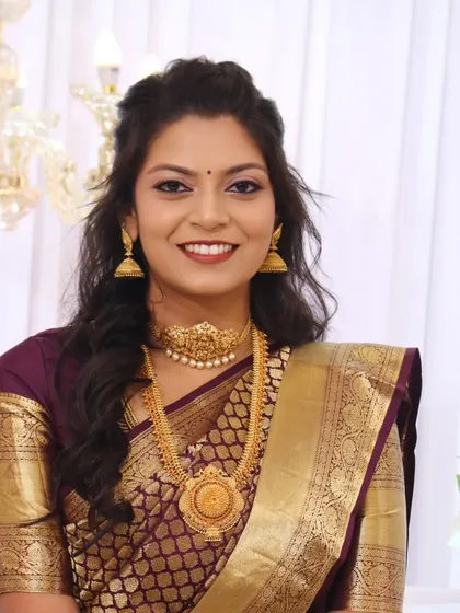 The complete South Indian bridal look, with makeup that enhances her features and complements the rich colors of her saree.