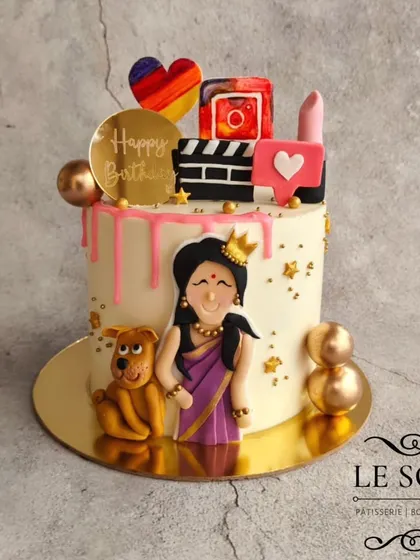 A cake that totally fits the vibe of a content creator. This 1 kg Chocolate Truffle cake is decorated with a custom figurine, her dog, and fondant elements like an Instagram logo, lipstick, and a movie clapperboard.