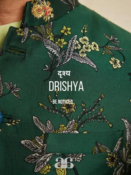 A detailed close-up of the emerald green bundi's fabric. The exquisite embroidery and custom buttons showcase the artistry involved in creating our garments.