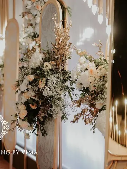 A classic and elegant reception setup symbolizing everlasting love. The stage features a modern, minimalist backdrop with custom monograms, floral arrangements, and soft lighting.
