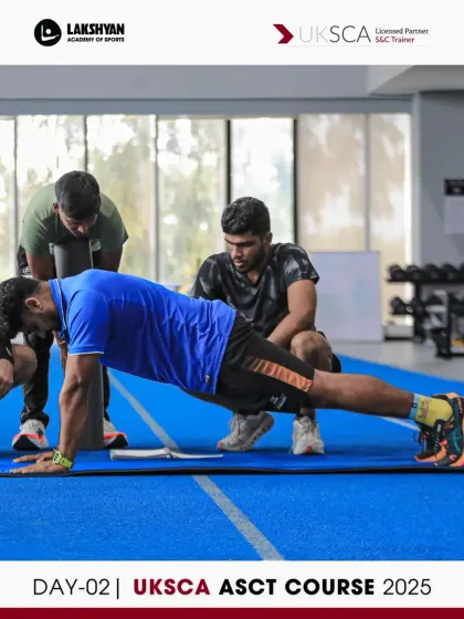 Participants work in groups to refine their coaching cues for core exercises like the plank. This collaborative practice is a core part of the Day 2 curriculum.