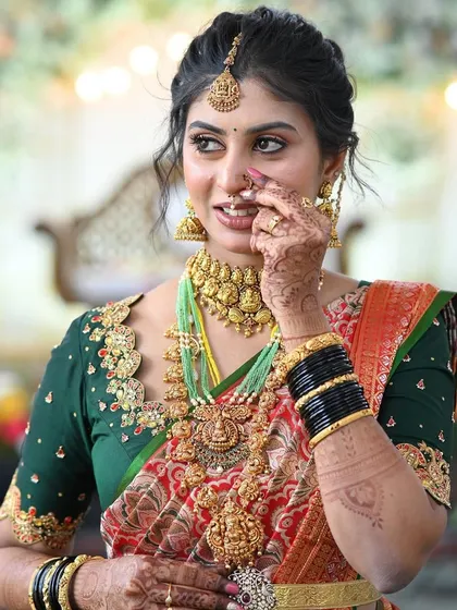 The joy on a client's face is my biggest reward. Here is a beautiful bride looking radiant in her custom-designed green blouse with delicate embroidery that perfectly complements her traditional red and gold wedding saree.