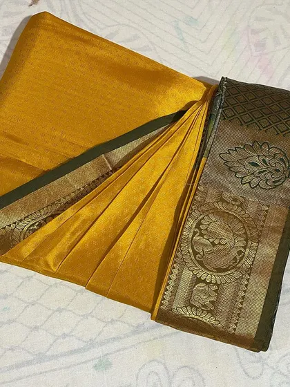 A mustard yellow silk saree with a traditional border, neatly pleated. This service is perfect for preparing your sarees ahead of a busy wedding season.
