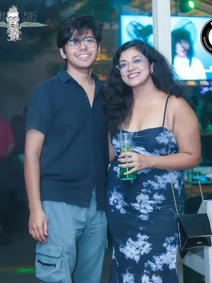 A couple enjoying a drink and the vibrant atmosphere of the party.