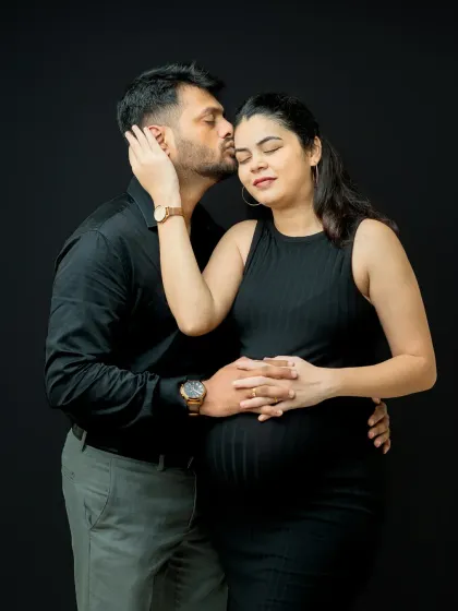 Another intimate pose against the black backdrop. This shot captures a moment of affection and closeness, with the focus entirely on the couple's connection.