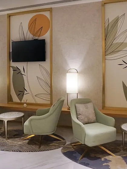 The main lounge area at the VVIP Lounges in Bangalore International Airport's Terminal 2. We designed this space to feel verdant and serene despite having no natural light, using a soft green color palette, custom lighting, and botanical-themed wall panels to create an oasis for travelers.