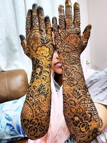 A lovely shot of a mom-to-be with her full-arm baby shower mehndi. The design is both celebratory and beautiful.