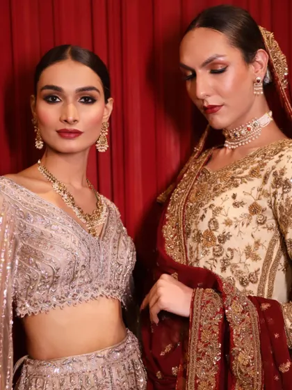Two models showcasing the beautiful work of our students backstage. They learn to create cohesive looks that align with the designer's vision.