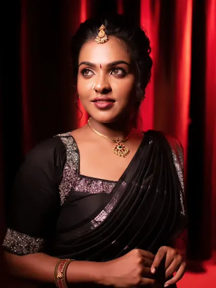 A bold and beautiful look with a black saree. The makeup is striking, with defined eyes and a confident pose.