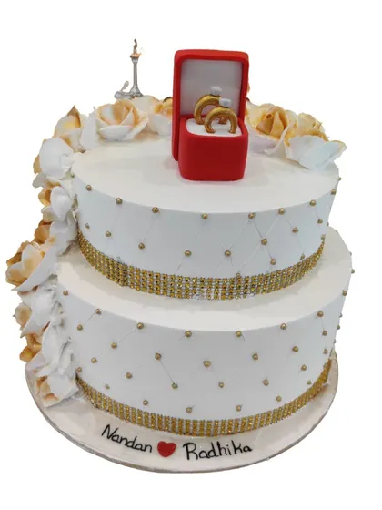 I designed this two-tier engagement cake with a quilted pattern, shimmering gold ribbon, and a beautiful edible ring box on top. It's a sweet and stylish way to announce your commitment.
