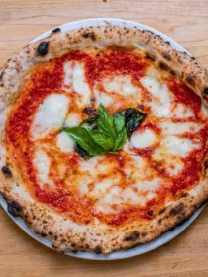 A simple, perfect Margherita pizza. The quality of the fresh dough, tomato sauce, and mozzarella cheese shines through in this Italian classic.