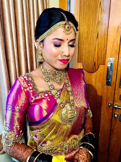 A candid moment showing the bride's makeup from the side. The contouring is soft and natural, and the pop of pink on the lips and cheeks adds a fresh, youthful glow.
