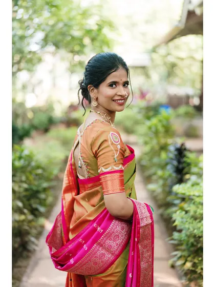A radiant bridal portrait in a garden, her bright smile and colorful saree creating a beautiful image of joy and anticipation.