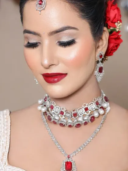 A classic reception look with a bold red lip and silver glitter eyes, created by a student.