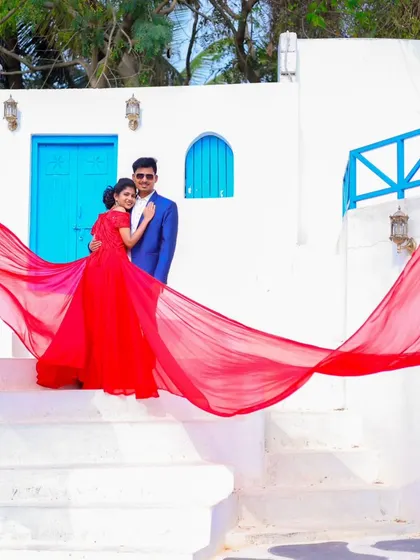 A beautiful composition with the couple framed by the steps and the long, flowing red fabric of the gown.