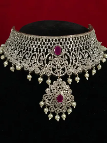 This Victorian-style CZ choker with a ruby pendant is a piece of art. The intricate design and pearl drops add a touch of vintage charm.