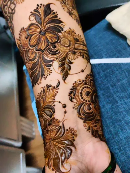 A close-up of a detailed floral and paisley design on the forearm, perfect for a party or special event.