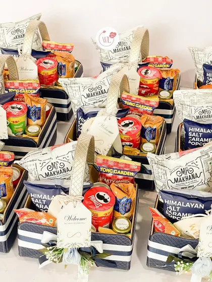 A lineup of welcome hampers ready for delivery. The consistent packaging with striped baskets and custom tags creates a professional and cohesive look for your wedding.