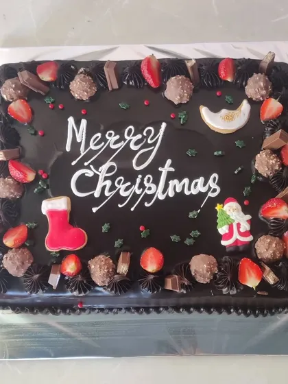 A rich chocolate slab cake for a large Christmas gathering, loaded with Ferrero Rocher, strawberries, and festive decorations.