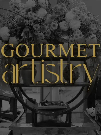 This image, with the overlay "Gourmet Artistry," captures our philosophy. The beautifully arranged floral centerpiece stands as a testament to our belief that food presentation is an art form.