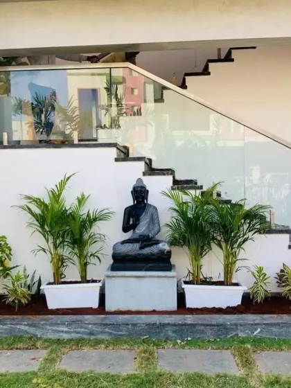 We design tranquil, Zen-inspired spaces using elements like this hand-carved Buddha statue and lush Areca palms. It's the perfect way to add a sense of peace to your home garden.