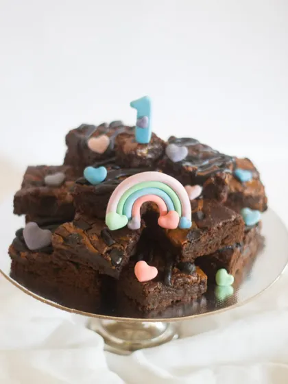 A brownie tower is such a fun alternative to a traditional birthday cake! This one was for a first birthday with a sweet rainbow theme. The brownies were a vegan peanut butter flavor, but I can customize them with your favorite add-ins.
