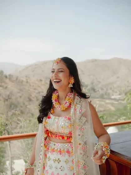 The pure joy of a Haldi ceremony. This bride's makeup is fresh and dewy, with a natural finish that lets her infectious laugh be the main focus.