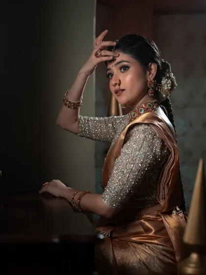 A portrait that captures the grace of a dancer. The bride's elegant hand gesture and expressive eyes, combined with soft lighting, create a photo that is both beautiful and full of character.