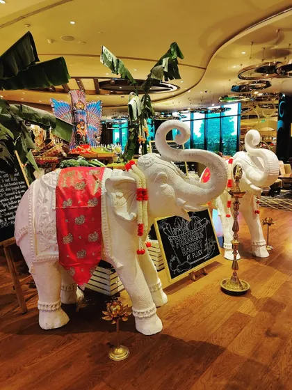Another angle of the elephant statues, set against a backdrop of banana leaves and other tropical foliage. This composition creates a lush, jungle-like feel inside the hotel space.