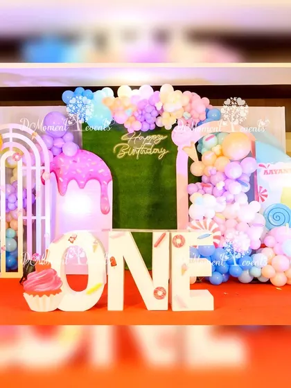 A close-up of the Candyland stage, highlighting the "ONE" marquee letters decorated with candy details and the dripping icing prop.