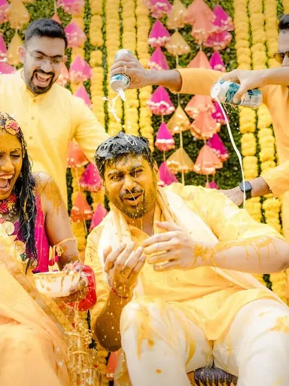 The celebration gets wild with friends spraying the couple with party foam during their Haldi, adding to the fun and chaos.