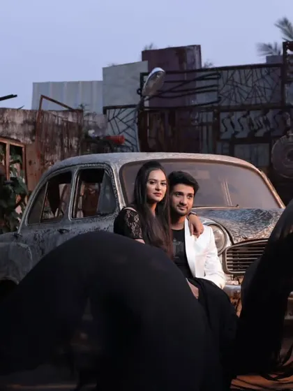 An edgy and cool pre-wedding shoot with a vintage car. The couple's black flying gown and white blazer combo creates a stylish contrast.