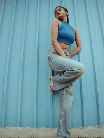 A different pose from the blue wall series. This shot shows a playful leg-up pose, adding variety and energy to a model's portfolio.