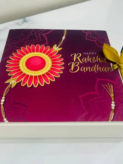 The beautiful Rakhi-themed packaging I use for my gift boxes. This sleeve with a floral rakhi design adds a special festive touch to your present.