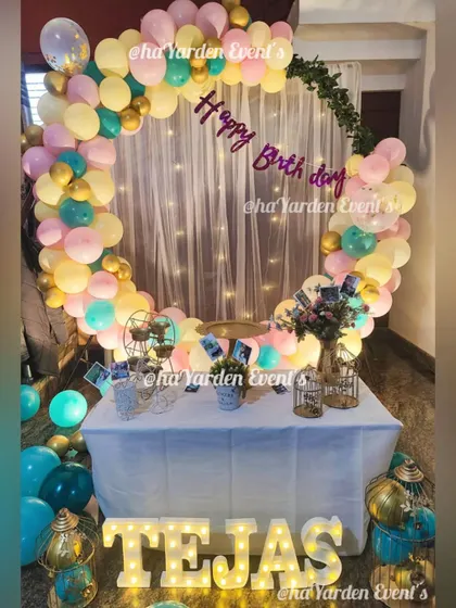 A pastel-colored balloon ring in front of a fairy light curtain, perfect for a soft and dreamy theme.