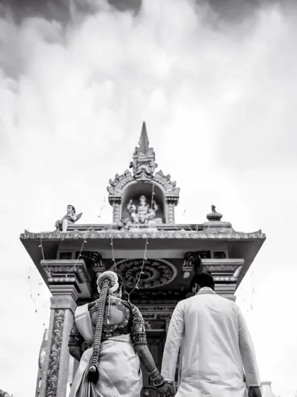 A powerful black and white shot of the couple walking towards a temple, symbolizing their journey together in faith.