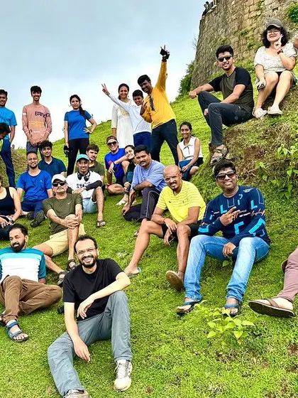 A happy, tired group relaxing on a grassy slope. These are the moments of rest and connection that make our treks so special.