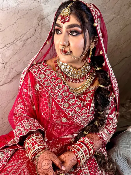 A breathtakingly beautiful bride. This look features dramatic eye makeup and a traditional braided hairstyle, perfect for a Punjabi or Rajasthani-inspired wedding.