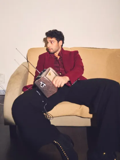 A playful moment from the shoot with Siddhant. The retro radio prop perfectly complements the vintage vibe of his flared trousers and tailored jacket.