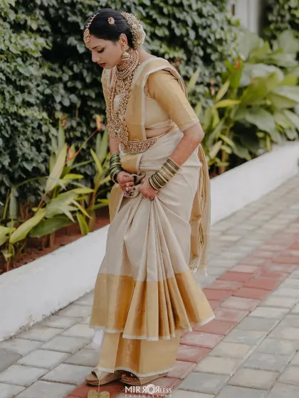 A full-length shot showcasing the beautiful drape of the Kanjeevaram saree and the bride's graceful posture.