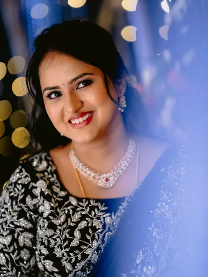 A beautiful smile from the bride at her reception. Her makeup is classic and elegant, with a pop of red on the lips.