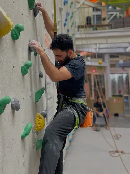 A climber works his way up a route, focused and determined. Kickstart your year with a new challenge and discover the thrill of climbing.