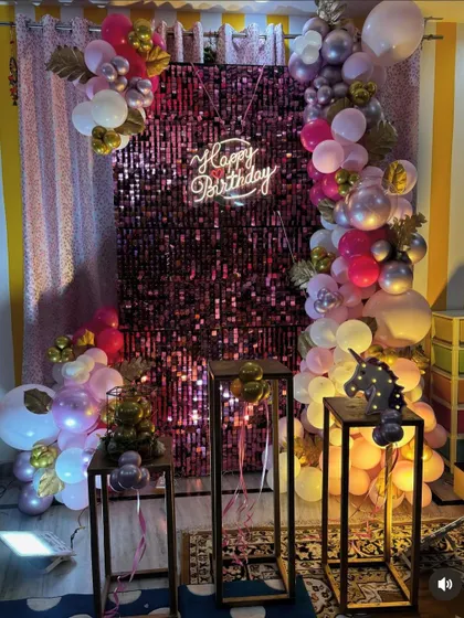Another view of the pink shimmer wall decoration, showing a light-up unicorn prop as part of the setup.