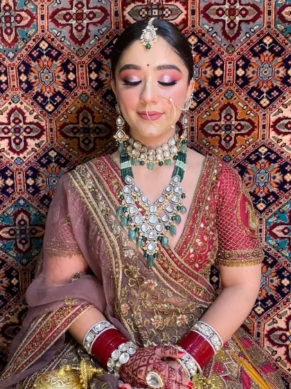 A close-up on the eye makeup for this traditional bridal look. The blend of pink and gold eyeshadow with a sharp liner makes her eyes pop, complementing the heavy jewellery and outfit.
