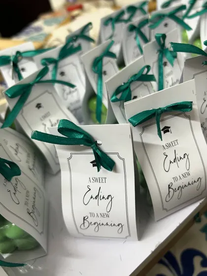A closer look at the graduation-themed bubble candle favors. The custom tag and green ribbon make it a thoughtful gift for students.