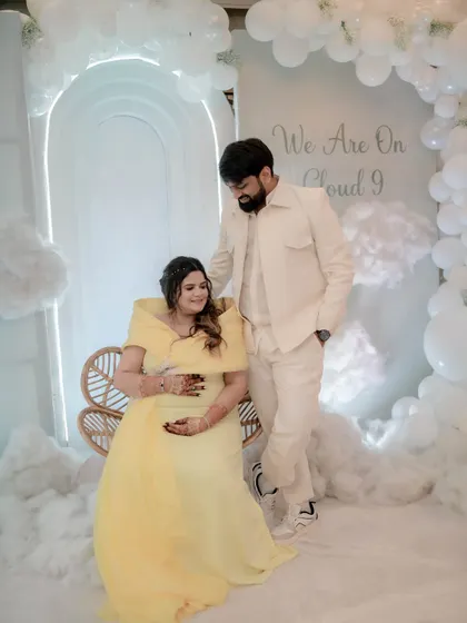 A beautiful portrait of the parents-to-be, seated among the clouds. The soft yellow of the mother's dress was a perfect complement to the white decor.