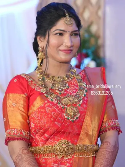 This bride looks radiant in a classic temple jewellery set, complete with a choker, haaram, and a detailed vaddanam.