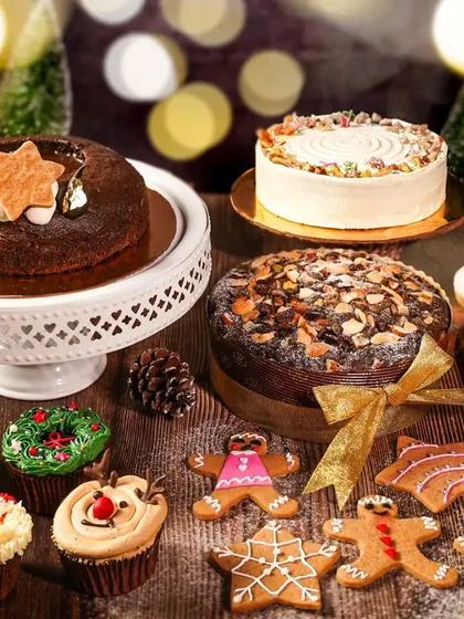 A beautiful spread of Christmas cakes and cookies, with warm bokeh lights in the background. This shot captures the magical, cozy feeling of a holiday bakery.