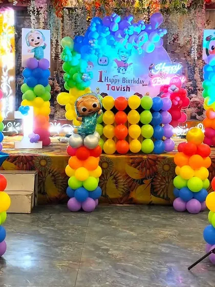 A close-up of the Cocomelon stage decoration. You can see the colorful balloon pillars, the custom backdrop with the birthday boy's name, and multiple character foil balloons that bring the theme to life.