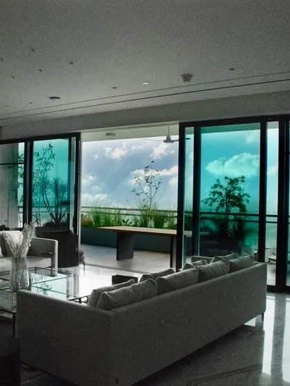 A thing of beauty is a joy forever. The view from this living room, looking out onto a high rise balcony garden against a backdrop of the sky, infuses the home with life and energy.